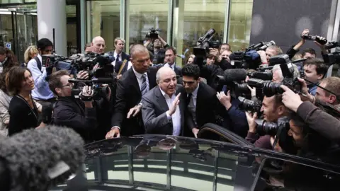 Getty Images A huge crowd of cameramen push against security personnel escorting an older Berezovsky to his car outside court