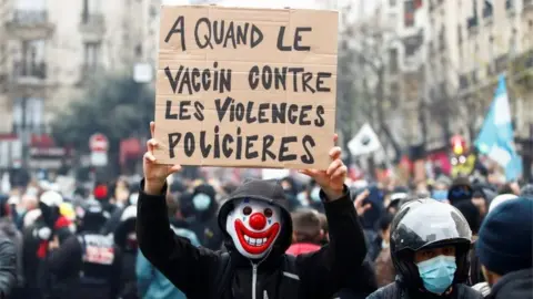 Reuters A demonstrator holds a placard reading "When will there be a vaccine against police violence" during a demonstration in front of a hospital in Paris, France, on 5 December 2020