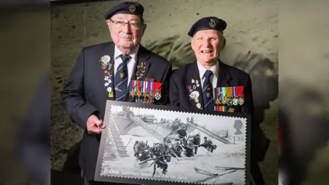 SoNT Two veterans standing with a stamp wearing medals