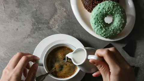 REDA&CO/GETTY Coffee cup and doughnut
