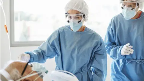 Getty Images Health workers with a patient