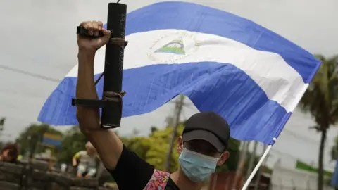 EPA A young protester raises his artisan weapon and the Nicaraguan national flag, in Managua, Nicaragua, 15 June 2018.