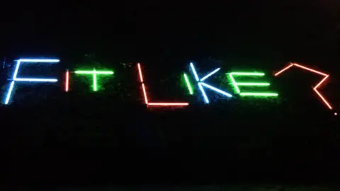 Emma Henderson Spectra lights saying 'Fit like?'