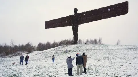 Owen Humphreys/PA Media People at a snow covered Angel of the North in Gateshead.