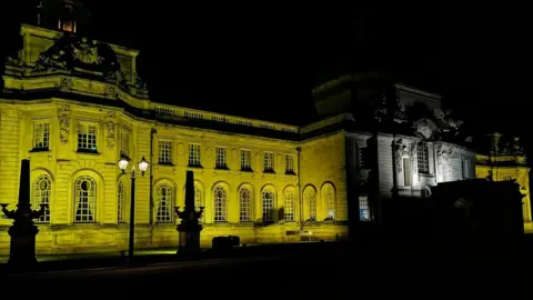 @YiannaBarla/Twitter Cardiff City Hall in yellow light