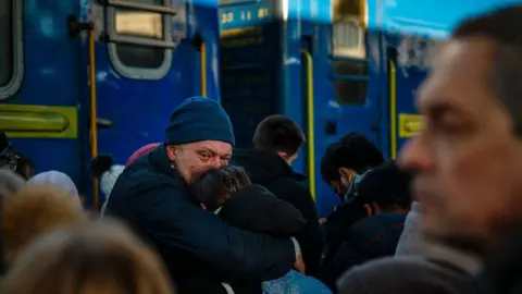 AFP A man says goodbye to his daughter before she boards an evacuation train at Kyiv's central railway station on 28 February 2022