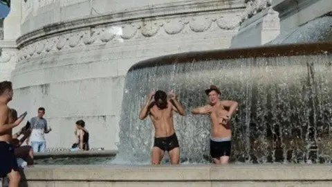 @RomaFaSchifo/Twitter A photo of two foreign tourists frolicking in the fountain, taken from the Roma Fa Schifo twitter feed with permission