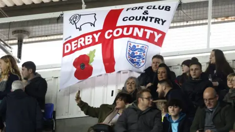 PA Media Derby County fans with flag