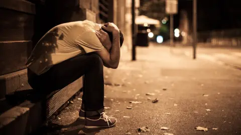 Getty Images Man in street with head in hands