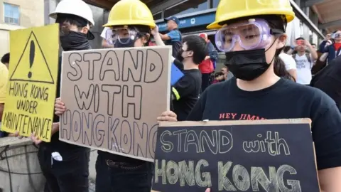 AFP Hong Kong pro-democracy supporters hold signs during a rally in Vancouver