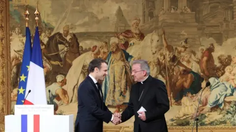 AFP Luigi Ventura shaking hands with Emmanuel Macron