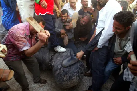 Getty Images Beating a statue of Saddam Hussein in Baghdad