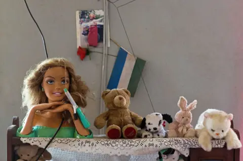 Lee Price Dolls and cuddly toys lined up on a table