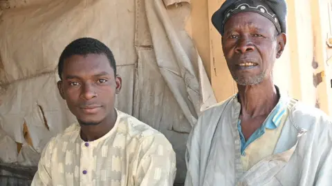 Nduka Orjinmo/ BBC Two men sitting on a bench