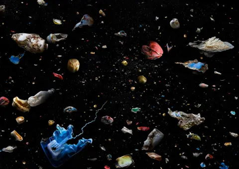 Mandy Barker Collection of marine debris against a dark background