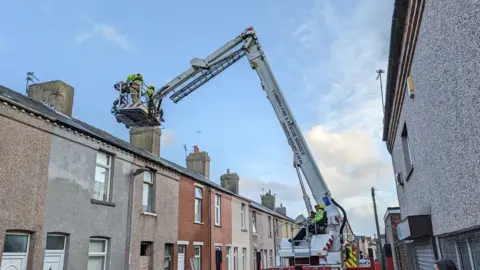 RSPCA Firefighters on a cherry picker get up to the roof