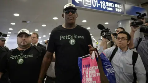 AFP Former NBA basketball player Dennis Rodman of the US gestures as he arrives to check-in for his flight to North Korea at Beijing"s international airport on June 13, 2017.