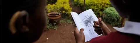 AFP Two pupils read a book in Kenya