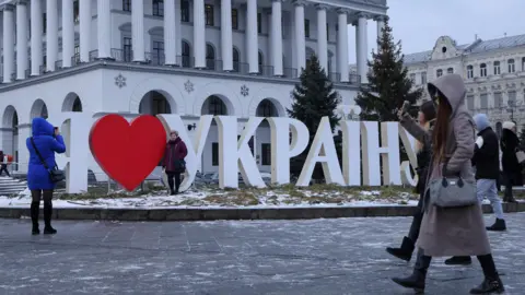 Getty Images People walk past giant letters that say "I love Ukraine" in Ukrainian in the capital Kyiv. Photo: 21 January 2022