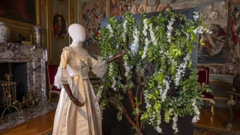 Blenheim Palace Mannequin with a period dress in front of artificial wisteria