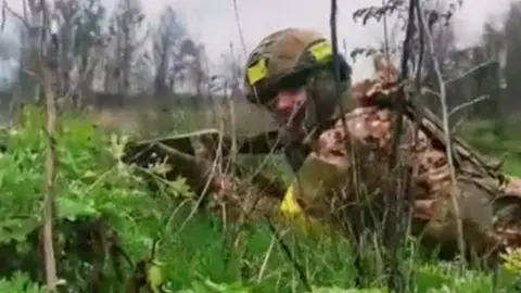 Soldier on ground with yellow armband