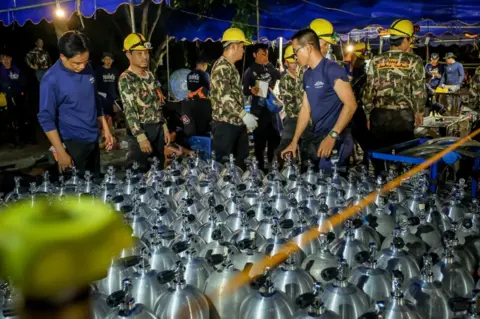 Getty Images Scuba tanks are delivered to the rescue operation site for the Thai navy