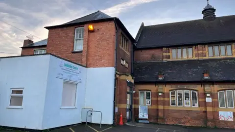 Ollie Conopo/BBC Brick-built two-storey school building with Doddridge Centre sign