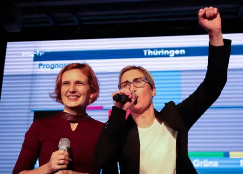 AFP Co-leader of Germany's left-wing Linke party Katja Kipping and Thuringian State Chairwoman, Susanne Henning-Welsow, react on stage to the first forecasts of the results of the state elections in Thuringia, at the federal state parliament in Erfurt, eastern Germany on October 27, 2019