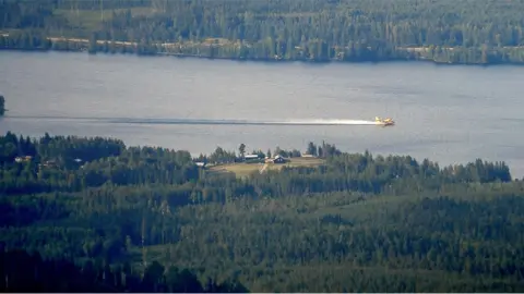 EPA 2 An Italian Bombardier CL-415 SuperScooper taking in water to drop on a large wildfire near Ljusdal, Sweden on 18 July 2018.