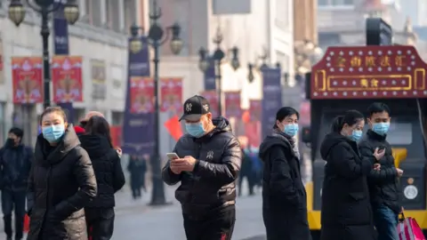 Getty Images People wearing masks walking on the famous business street of Binjiang Dao, at downtown Tianjin.