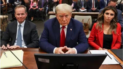 Getty Images Trump flanked by lawyers at his civil trial in New York