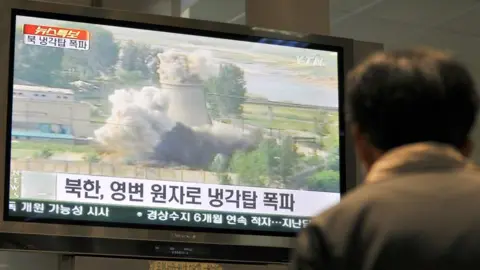 Getty Images A South Korean looks at footage of the demolition of North Korea's cooling tower at its Yongbyon nuclear complex