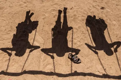 AFP Child refugees from the Democratic Republic of Congo (DRC) play on on swings at the Nyakabande Transit Center in Kisoro, Uganda.