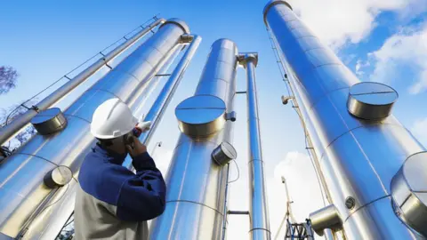 Getty Images A worker by vertical pipelines