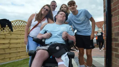 PA Media/Band of Builders Luke Goold-Hannatt with his family