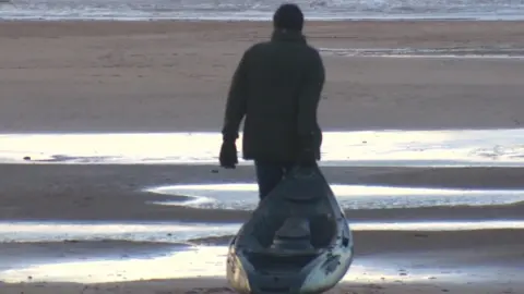 man dragging kayak