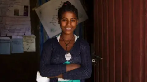 UNICEF Abeba stands by her school's doors