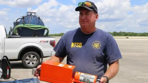 Handout via Reuters A National Transportation Safety Board (NTSB) investigator is seen with flight data recorder