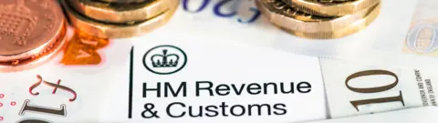 Getty Images Money and a document with the HMRC logo