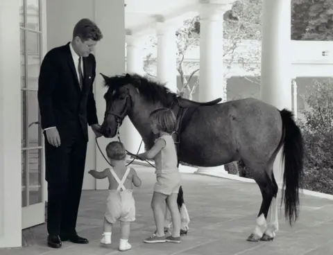John F. Kennedy Presidential Library & Museum/NARA President Kennedy is seen with his daughter Caroline, son John and pet pony Macaroni