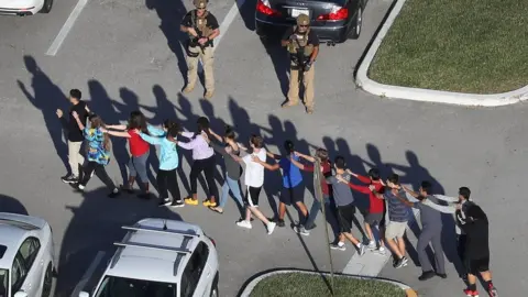 Getty Images People are brought out of the Marjory Stoneman Douglas High School after a shooting at the school that reportedly killed and injured multiple people on February 14, 2018 in Parkland, Florida.