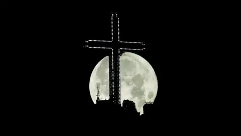 Ognen Teofilovski / Reuters The moon rises behind the 66m (217ft) high Millennium cross in Skopje, North Macedonia