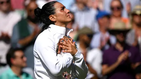 Reuters Tunisian tennis player Ons Jabeur hugging the runners-up trophy at Wimbledon, London, the UK - Saturday 9 July 2022