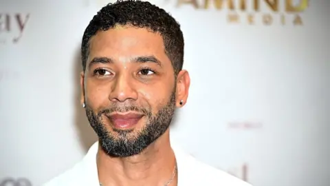 Getty Images Jussie Smollett at an event in New York in September 2024. Smollett has short hair and a trimmed beard and is pictured wearing a white blazer.