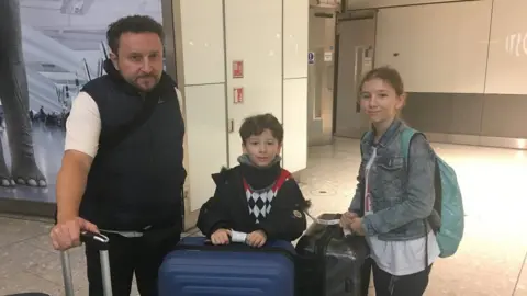 BBC Daniel Maloney and children Freddie and Isabella at Heathrow airport