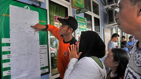 Antara Foto via Reuters A women cries as she reads a list of victims who were killed in a tsunami, at Carita in Padeglang, Banten province, Indonesia, December 23, 2018