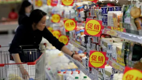 Getty Images Woman in China shopping for dairy products