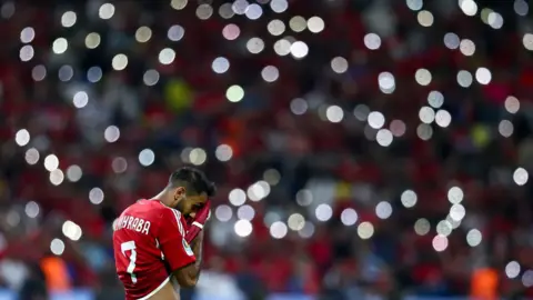 NurPhoto via Getty Images Mahmoud Kahrba, who plays for Egyptian club Al-Ahly, wipes his brow in Friday’s football game against Algeria’s USM Alger.