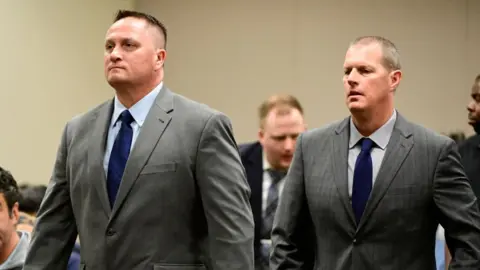 The Denver Post via Getty Images Paramedics Jeremy Cooper, left, and Peter Cichuniec, right, at an arraignment in the Adams County district court at the Adams County Justice Center January 20, 2023.