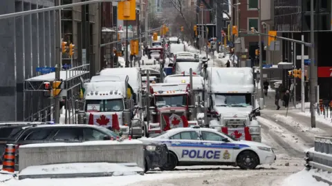 AFP via Getty Images Trucks parked in downtown Ottawa continue to protest Covid-19 vaccine mandates and restrictions, on 4 February 2022 in Ottawa, Canada